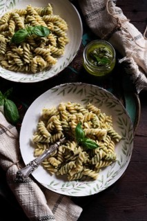 Delicious fusilli pasta served with flavorful green pesto sauce. Garnished with fresh basil leaves