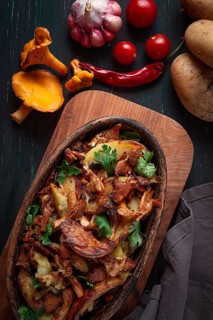 Fried chanterelles with potatoes, in a clay frying pan, top view, homemade, no people