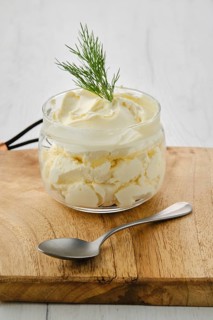 Closeup view of fat sour cream in a glass pot