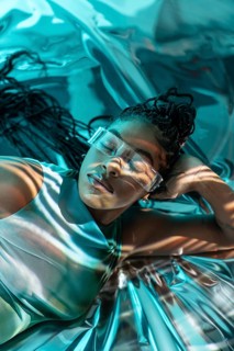 A futuristic African young woman in the metaverse, adorned with transparent glasses, lounges in a