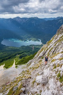 Via ferrata over the Riffelscharte, hiker in the mountains, view of Eibsee lake and Werdenfelser