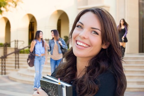 Smiling Mixed Race Young Girl with Books Walking On Campus