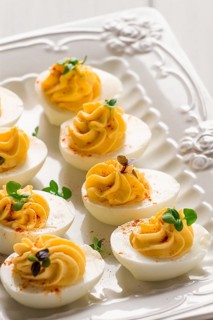 Boiled eggs stuffed with yolk with mayonnaise, on a white plate, selective focus, blurry, close-up,