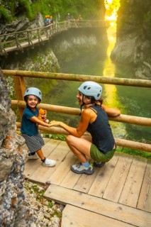 Mother and child wearing helmets enjoying the stunning scenery of vintgar gorge near bled,
