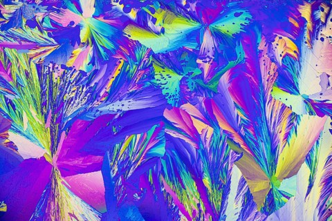 A vibrant microcrystals under the microscope, featuring a brilliant array of colors including