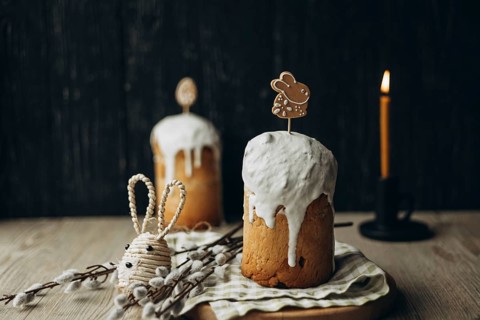 Traditional Russian Easter kulich, a tall bread topped with frosting, decorated with a festive