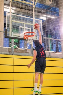 A player darkens with outstretched arms in a yellow gym, basketball TSV Calw, Germany