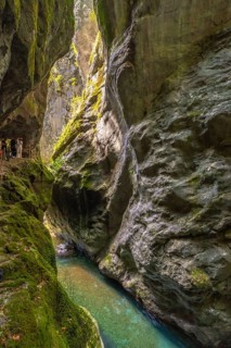 Tourists walking along a wooden pathway, discovering the stunning tolmin gorges in slovenia,