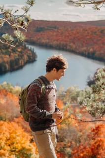 A person enjoys a peaceful hike in Quebec, Canada during autumn. The vibrant fall foliage surrounds