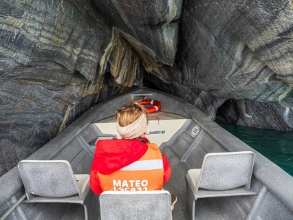 Woman sitting at the front of a tour boat, excursion boat inside the marble caves, Puerto Sanchez,