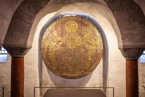 Close-up of a medieval, circular and fire-gilded copper disc, Christ disc from the 10th century (ca