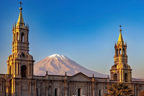 Cathedral with two towers in front of a majestic volcano at sunset, The Basilica Cathedral of