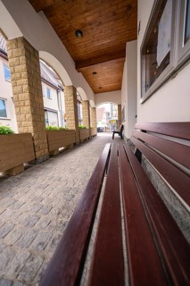 Rustic arcade with wooden benches and paved floor between buildings, Knittlingen, Germany