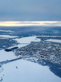 View of the snowy town of Rovaniemi with the Kemijoki river, in winter, aerial view, Finland