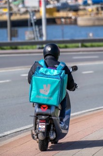 Food, food delivery service Deliveroo rider on moped in Antwerp, Flanders, Belgium