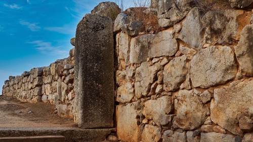 Cyclopean wall, gate, large old stone wall under a partly cloudy sky, Tiryns, ancient city in