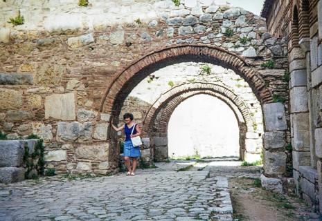 Female tourist standing under arches at Byzantine Monastery of Hosios Loukas Osios Loukas, Boeotia