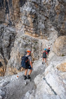 Three hikers on the Via Ferrate Benini via ferrata on a cliff, Brenta Mountains, Parco Naturale