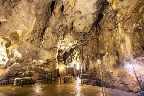 An illuminated cave with impressive rock formations and wet surfaces, The Hospital Cave on Cat Pa