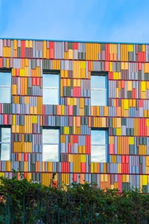 A striking view of a contemporary building featuring a multicolored facade with geometric patterns