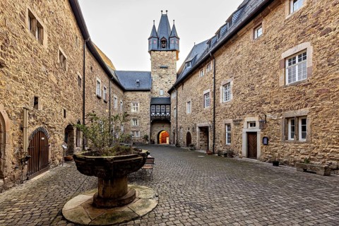 A courtyard steeped in history with stone walls, a tower and charming old buildings: the courtyard