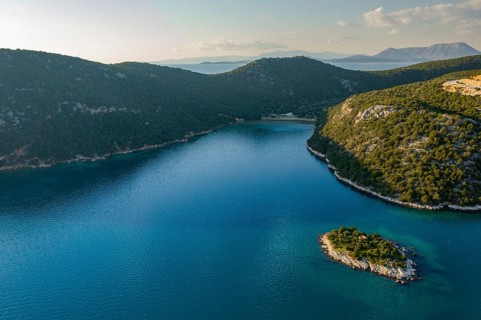 Stunning drone shot of Marathias wild beach, showcasing a peaceful cove with crystal-clear blue