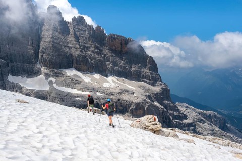 Hikers on hiking trail 305 cross a snowfield, Brenta Mountains, Parco Naturale Brenta-Adamello,
