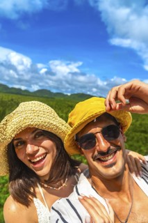 Tourists couple smiling and enjoying summer holidays in a coconut plantation on siargao island,
