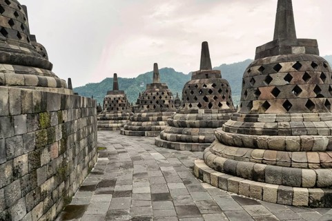 A serene morning at Borobudur Temple, capturing the intricate stonework and stupas against a lush