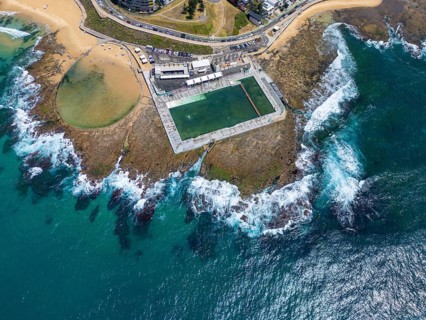 A stunning aerial view of an ocean pool nestled on the rocky coastline of New South Wales,