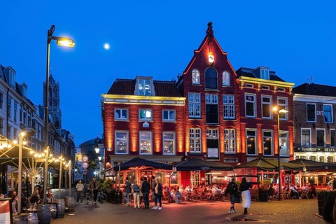 Nightlife at De Neude square in the background the bell tower of the cathedral in the historic