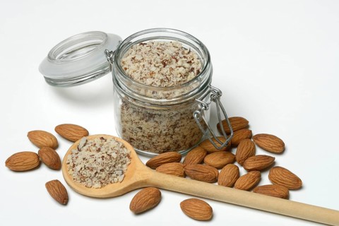 Almonds and ground almonds in glass, Prunus amygdalus
