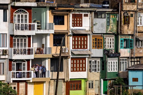 Multi-storey building with colorful facades and several balconies in an urban setting, A house