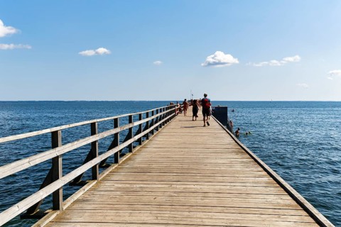 Walkers on bathing bridge in summer, Kalmarsundsbryggan pier, Cumulus, Baltic Sea coast, Kalmar,