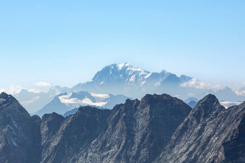 Stunning view of Zermatt's rugged mountains under a clear blue sky, featuring snow-capped peaks and