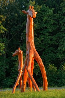 Giraffes made of red painted tree trunks, wooden sculpture by Günter Schumann, Museum of the