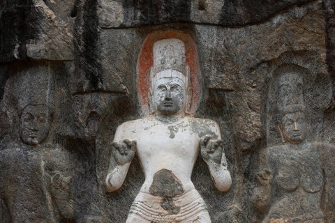 Detailed rock carvings depict sacred figures in Sri Lanka, showcasing intricate artistry and