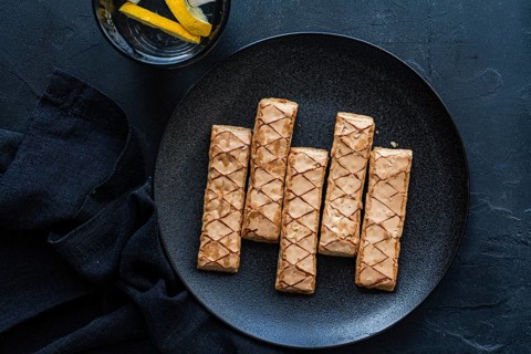 Delicious puff pastry sticks filled with sweet apricot jam on a sleek black plate. Ideal for