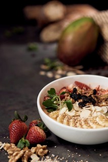 A nutrient rich breakfast natural bowl filled with strawberries, banana slices, nuts, raisins, and