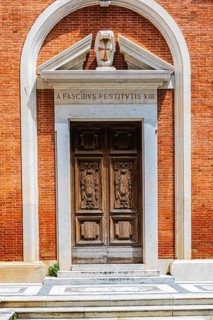 Decorated arched entrance gate in a brick façade, Pisa, Tuscany, Italy