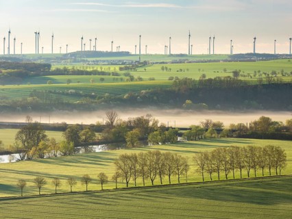 Morning atmosphere in the Saale Valley in spring, fog sweeping through the valley, wind turbines on