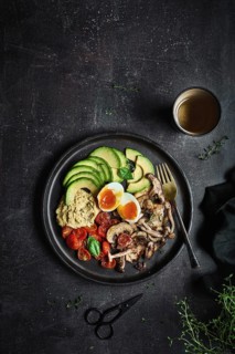 Overhead full plate of delicious dish with hummus from fried champignons and boiled eggs with