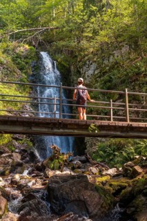 A woman on the upper part of a wooden bridge at the Todtnau waterfall in the Black Forest in