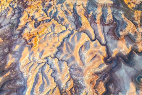 Captivating aerial view of golden bentonite formations in Utah, USA. The natural patterns and