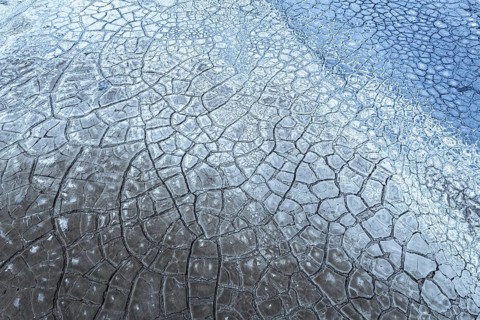 A mesmerizing abstract close-up image displaying cracked mud and earth textures, blending earthy