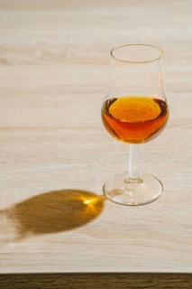 Glass of cognac on a table in a bright sunny day