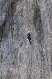 Worker climbing on a rock wall on the island of Capri, Campania, Italy