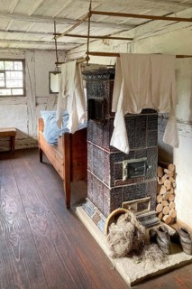 Historic dormitory with tiled stove at the back single bed for one person in old rebuilt restored