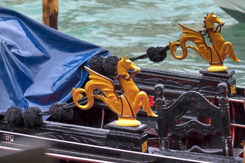 Gold-colored mythical animals decorate the gondola, Venice, Veneto, Italy