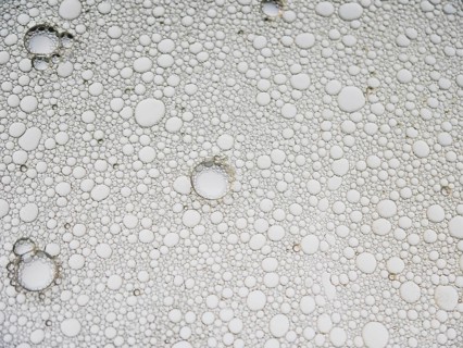 An abstract pattern featuring numerous bubbles in varying sizes, creating a distorted visual effect